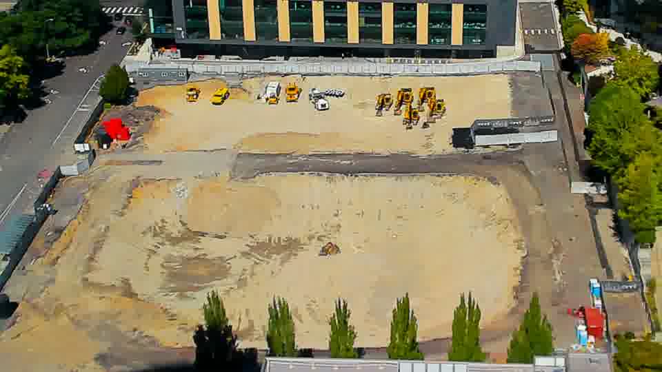 Construction camera frame at 1:15 PM PT. Equipment positions remain consistent across the site, with only subtle shifts in shadow patterns occurring during this period.
