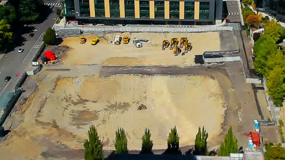 Construction camera frame at 2:00 PM PT. Shadows have subtly lengthened across the site, but the positions of equipment and materials appear to be the same.