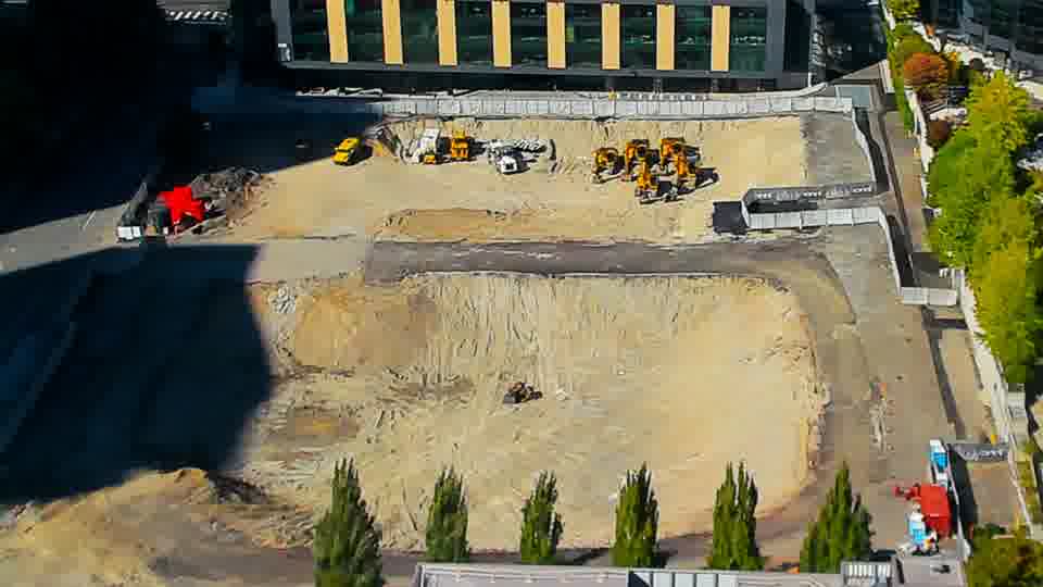Construction camera frame at 3:45 PM PT. A red truck has entered the site via the driveway on the left side of the frame. Otherwise, the equipment arrangement appears stable, with no other noticeable changes in position.