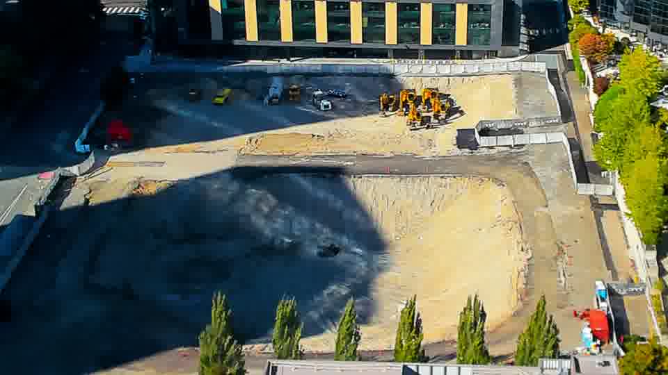 Construction camera frame at 4:15 PM PT. The scene is largely unchanged, with the same machinery visible in the same locations as the previous view.
