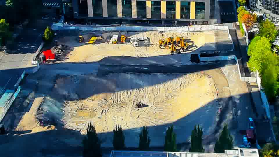 Construction camera frame at 5:15 PM PT. The equipment on the right side of the frame has shifted slightly, with one machine now positioned further forward. Otherwise, the site maintains a similar appearance to the previous view.