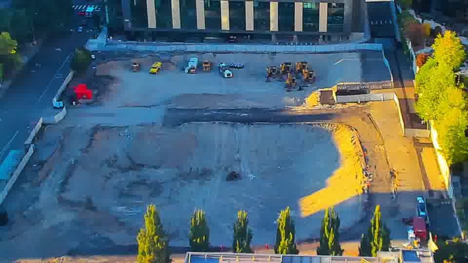 Construction camera frame at 6:45 PM PT. The arrangement of equipment across the site remains much the same as it was fifteen minutes ago.