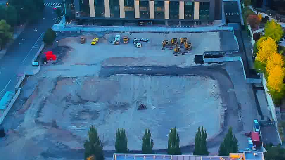 Construction camera frame at 7:15 PM PT. The scene is quiet, with no apparent changes to the location of equipment or materials since the last check-in.