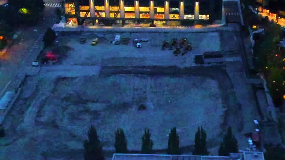 Construction camera frame at 6:30 AM PT. The site remains largely unchanged, with the same arrangement of equipment visible across the graded area.