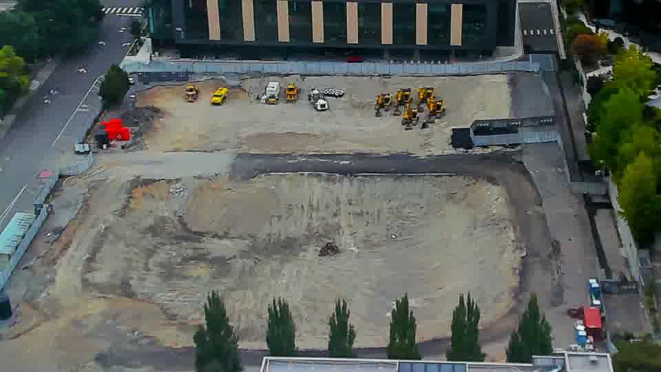 Construction camera frame at 10:15 AM PT. No discernible changes have occurred on the site in the last fifteen minutes, as all visible machinery and materials remain in the same locations.