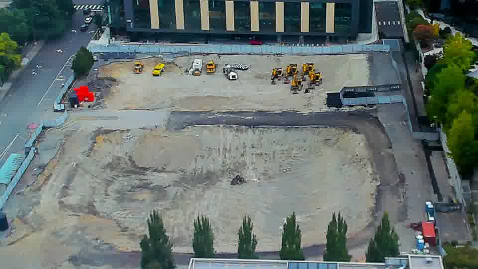 Construction camera frame at 10:30 AM PT. The site remains largely unchanged, with equipment positioned as it was moments ago.