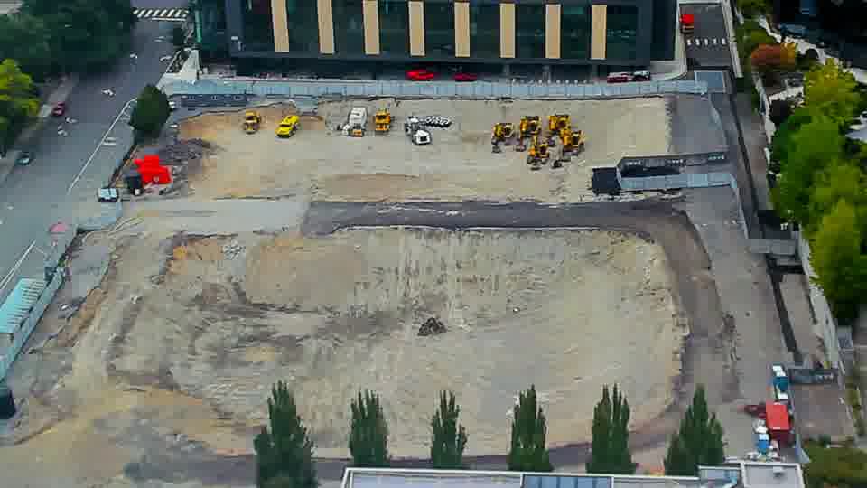 Construction camera frame at 11:15 AM PT. The site holds a quiet stillness, with all visible elements remaining in the same positions as before.