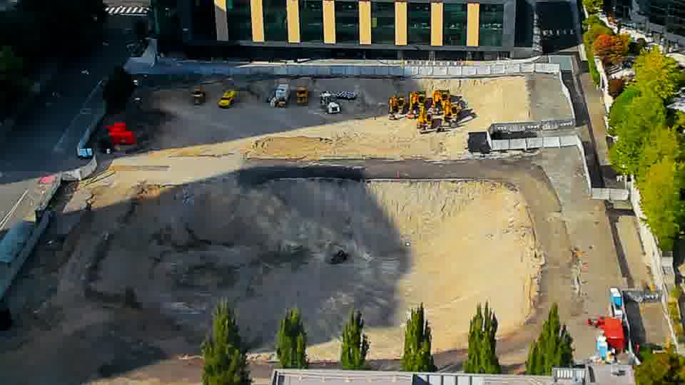 Construction camera frame at 4:15 PM PT. Shadows have shifted across the graded area, but all equipment and vehicles appear to remain stationary.