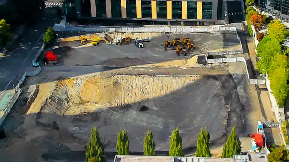 Construction camera frame at 4:45 PM PT. The view remains largely unchanged, with all visible machinery and materials holding their previous positions.