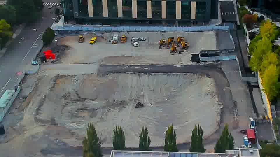 Construction camera frame at 7:00 PM PT. The site holds steady, with equipment remaining in the same locations as observed previously.