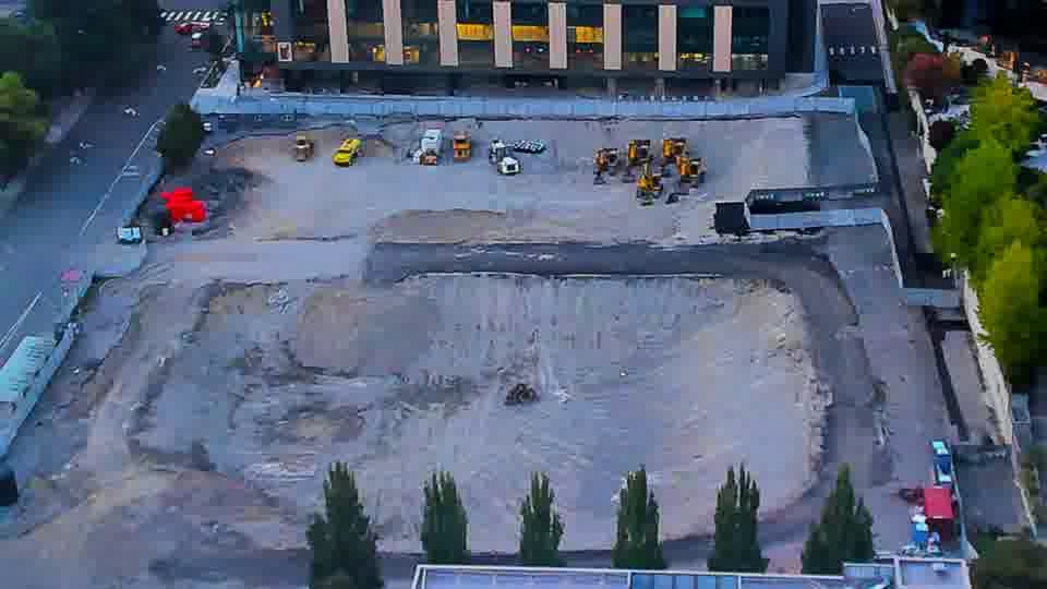Construction camera frame at 7:30 PM PT. No significant shifts are visible across the site, as the machinery and vehicles maintain their previous positions.