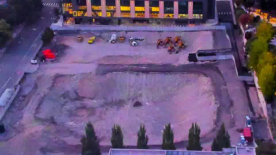 Construction camera frame at 7:45 PM PT. The view across the site is consistent, with no apparent repositioning of equipment or vehicles during this interval.