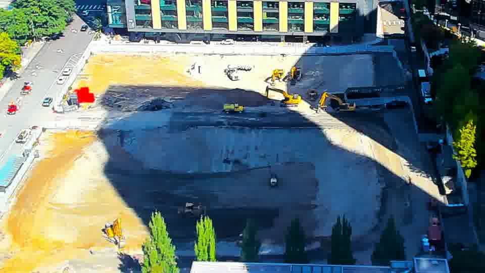Construction camera frame at 11:30 AM PT. A red truck has entered the site from the driveway on the left.