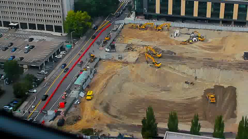 Construction camera frame at 3:00 PM PT. A large, light-colored truck has entered the site via the driveway on the left. Otherwise, no visible change between these frames.