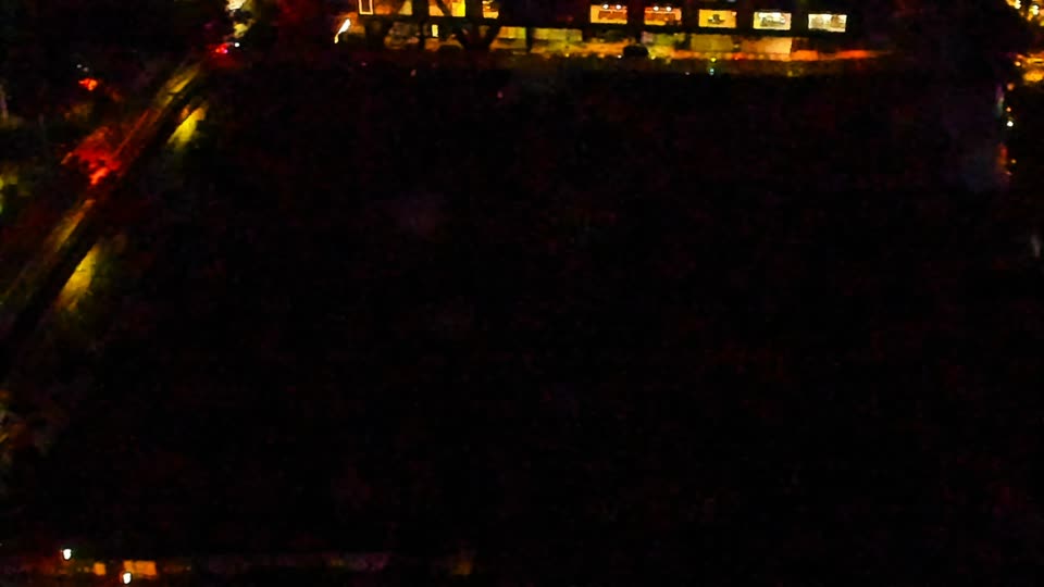 Construction camera frame at 11:00 PM PT. Visibility is too low to assess construction activity.