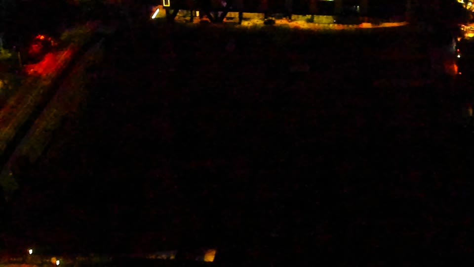 Construction camera frame at 12:00 AM PT. Visibility is too low to assess construction activity.