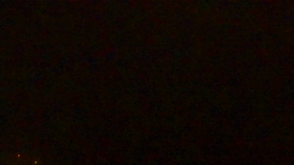 Construction camera frame at 5:00 AM PT. Visibility is too low to assess construction activity.