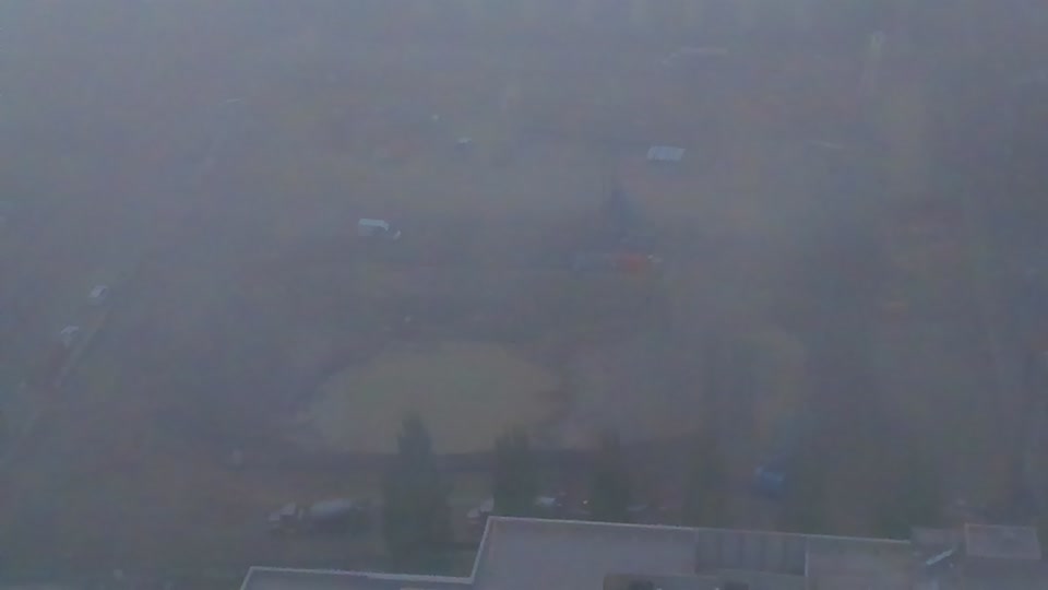 Construction camera frame at 8:45 AM PT. Visibility has improved slightly, revealing the site is shrouded in fog or haze.